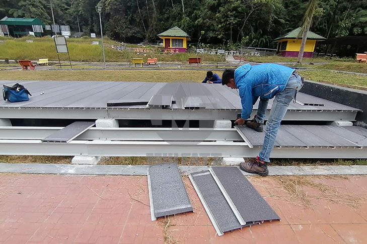 FRP Decking Installation for Event Space at Parit Falls Campsite - Worker installing durable FRP decking panels at Parit Falls Campsite event space for safe, long-lasting, and low-maintenance flooring solution