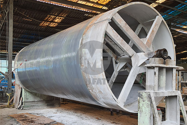 Large cylindrical FRP tank under fabrication using filament winding method inside Mui Fatt's manufacturing facility in Malaysia.