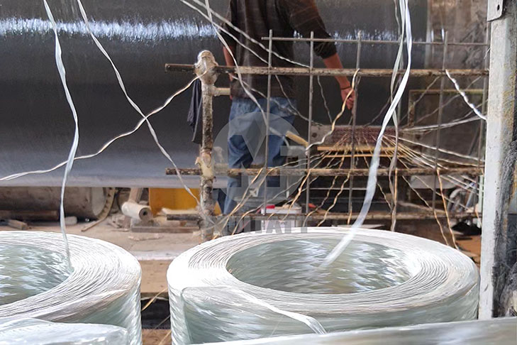 Close-up of fiberglass yarn spools and manual feeding during filament winding process at Mui Fatt factory.