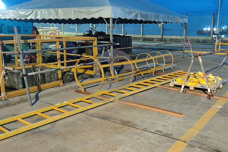 Pre-Installation Inspection of Mui Fatt FRP Caged Ladder for Edra Melaka Power Plant - Yellow Mui Fatt FRP caged ladder laid out for inspection at Edra Melaka Power Plant before installation, showcasing its corrosion-resistant and high-durability design for industrial safety.