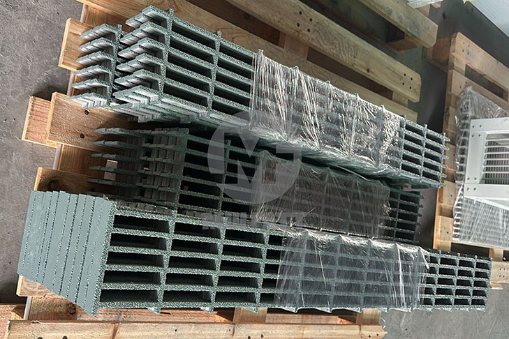 Close-up of stacked grey MG25-100 molded FRP grating panels on pallet before delivery to RNR Simpang Pulai and Gurun