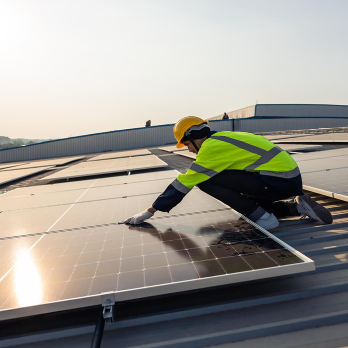 Worker performing Solar Panel maintenance on Rooftop